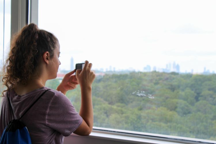 a woman uses her phone to take a skyline photo